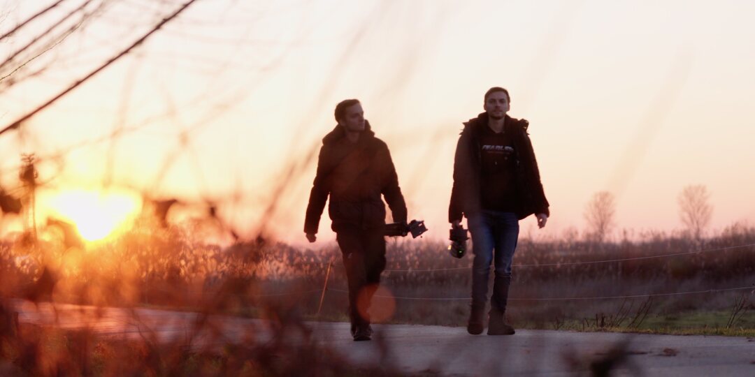 Die Zwillinge laufen auf einem Weg in den Sonnenuntergang.